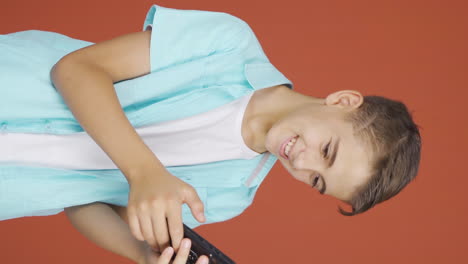 Vertical-video-of-Happy-boy-texting-on-the-phone.-Smiling.